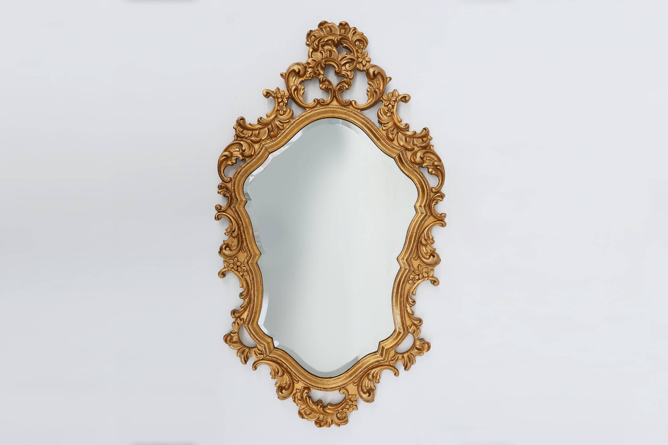 French Rococo or Baroque style facet-cut crest mirror in gilded carved wood