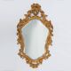 French Rococo or Baroque style facet-cut crest mirror in gilded carved wood