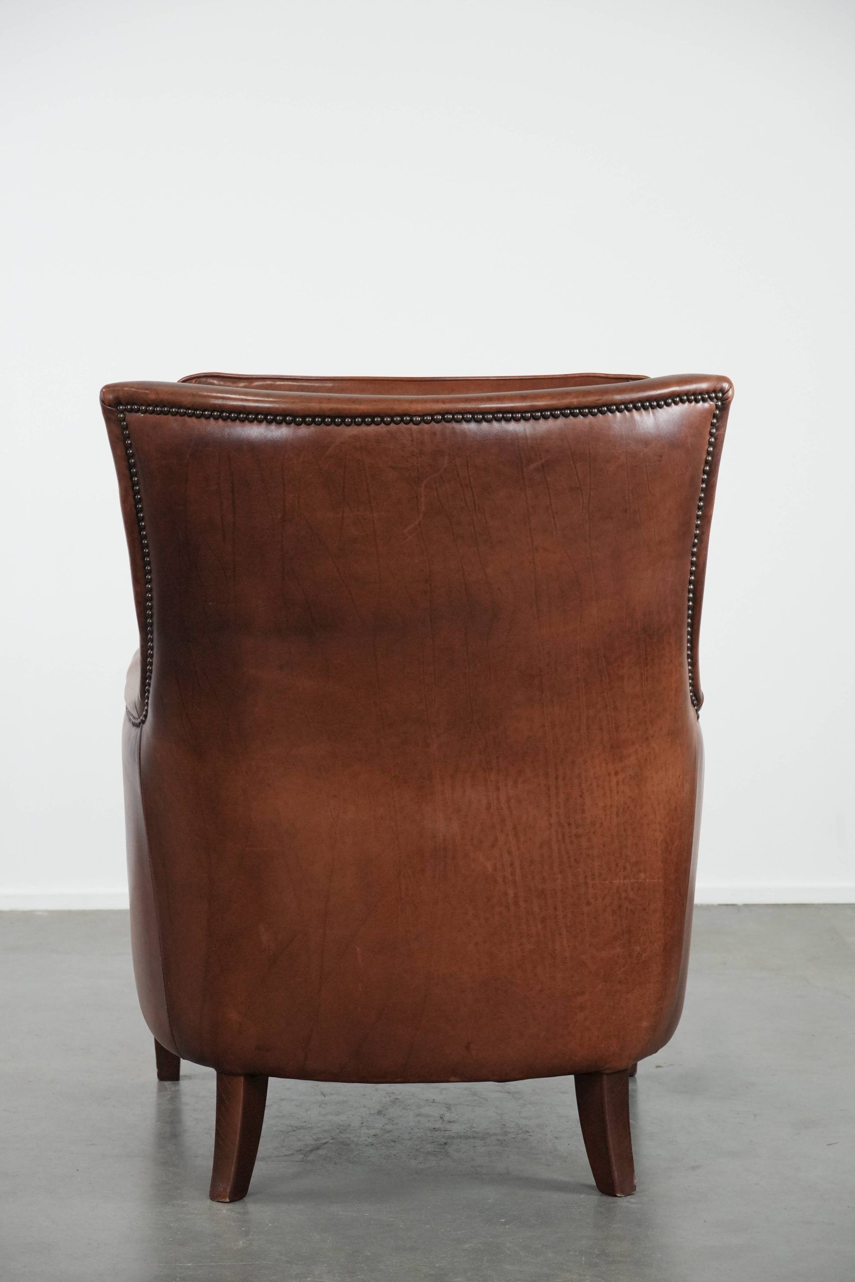 Cognac brown cow leather armchair with decorative nail finish
