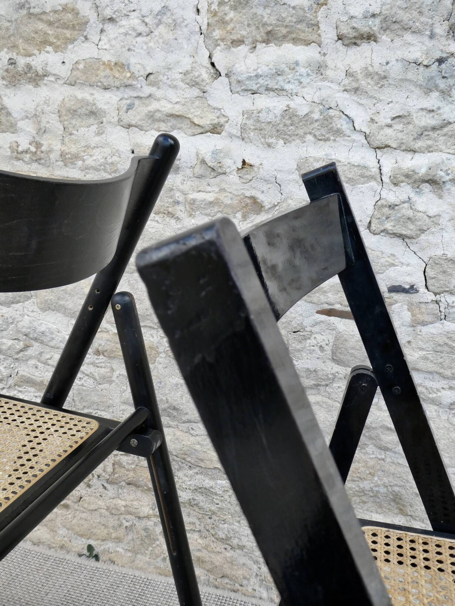 Paire de chaises pliantes en bois noirci et assise cannée