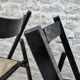 Paire de chaises pliantes en bois noirci et assise cannée
