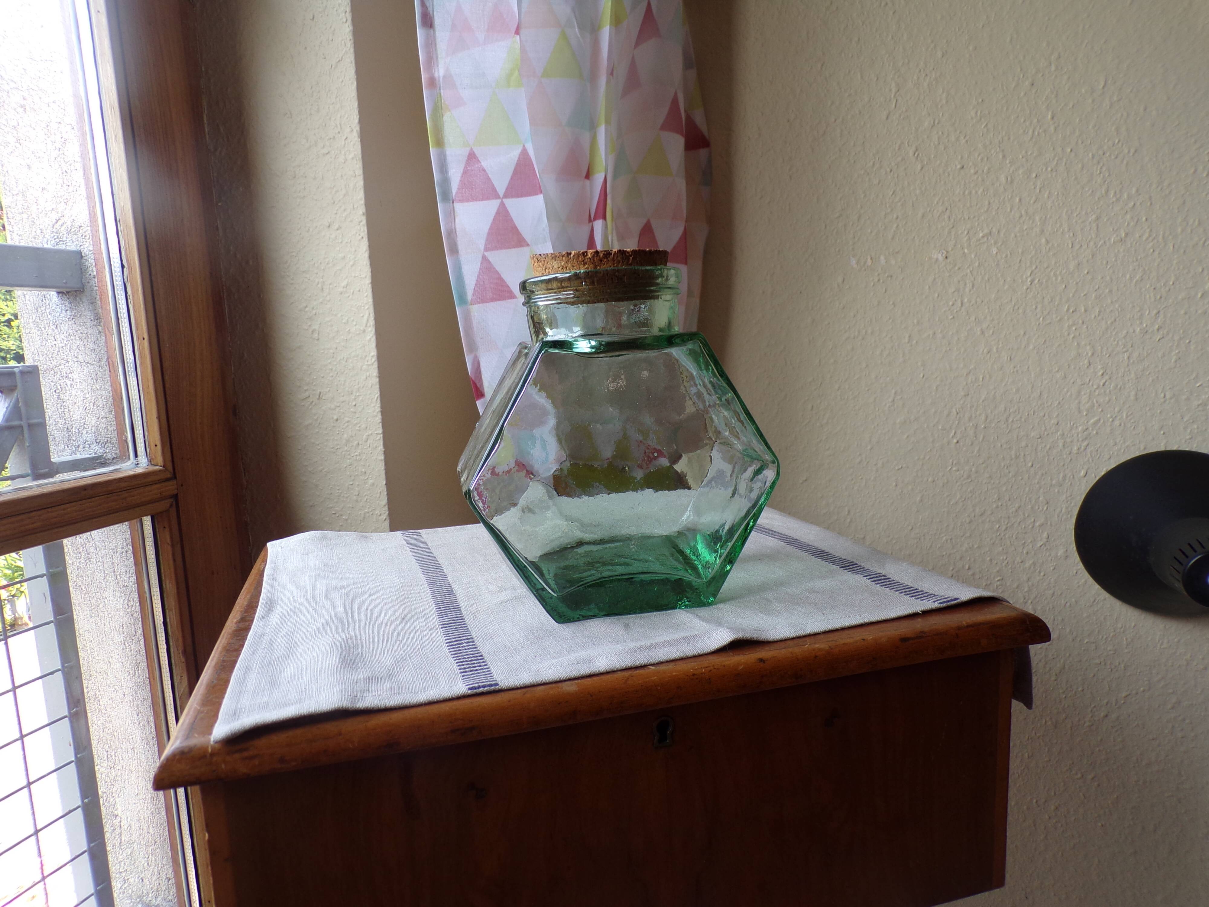 Old thick glass of a light green jar