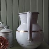 Old enamelled metal jug with gold trim.