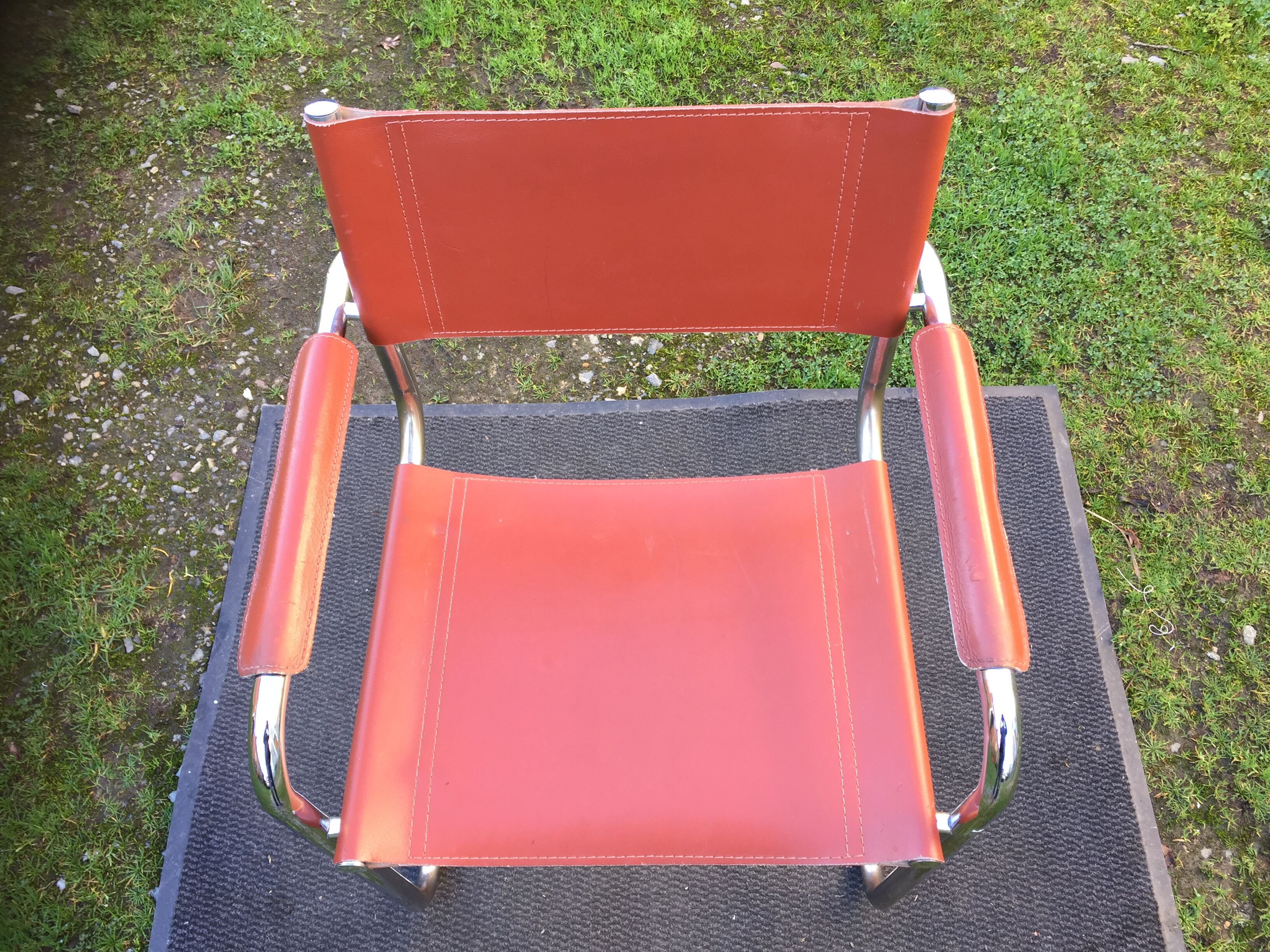 Design armchair with base in chrome tubular steel and seat in brown leather