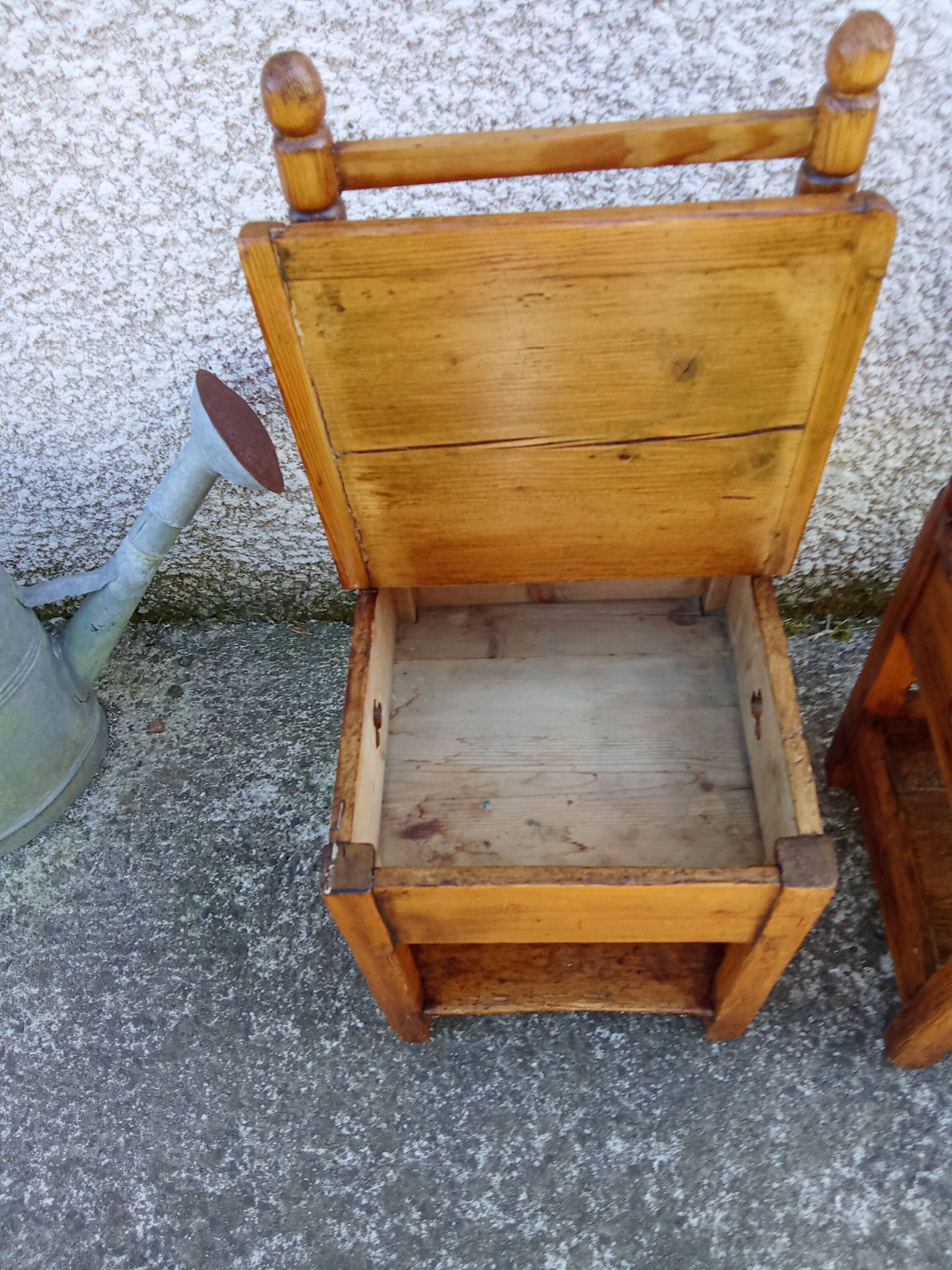 2 old wooden children's chairs with a small chest.