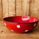 Ceramic salad bowl in red with white polka dots.