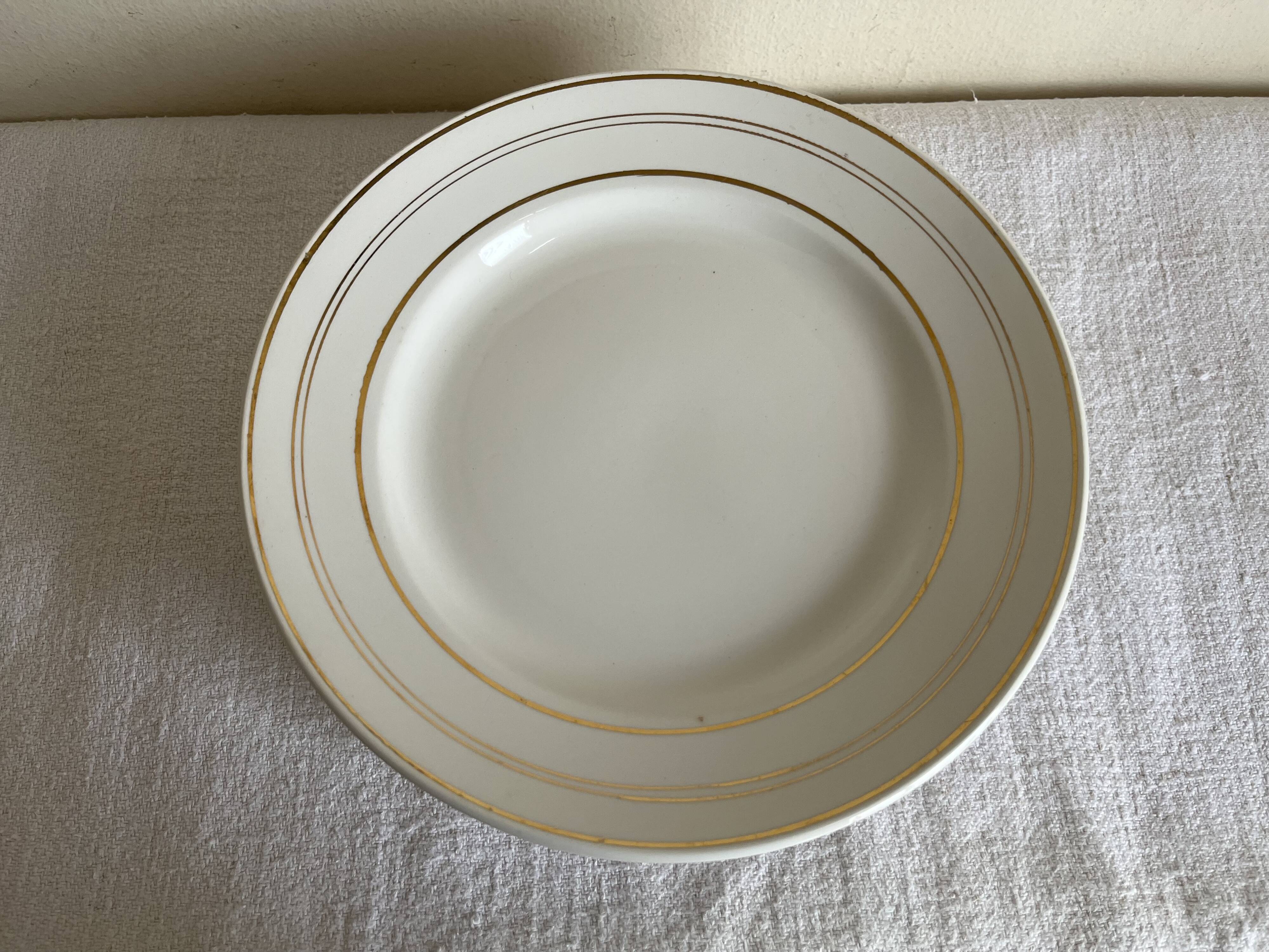 Set of 8 modernist flat plates in fine earthenware with pure gold trim, 1930.