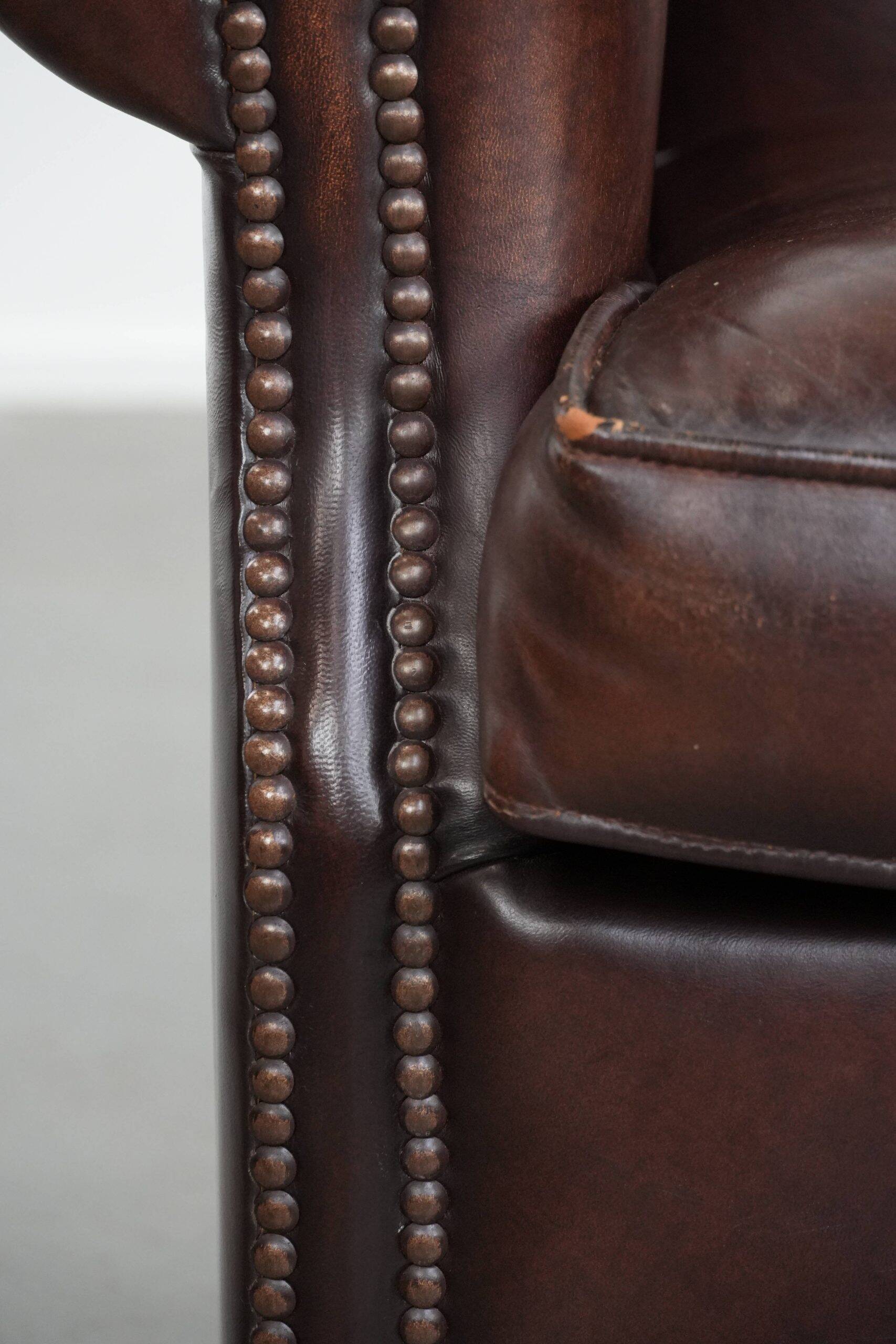Sheepskin armchair with a classic finish and decorative studs.