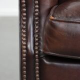 Sheepskin armchair with a classic finish and decorative studs.