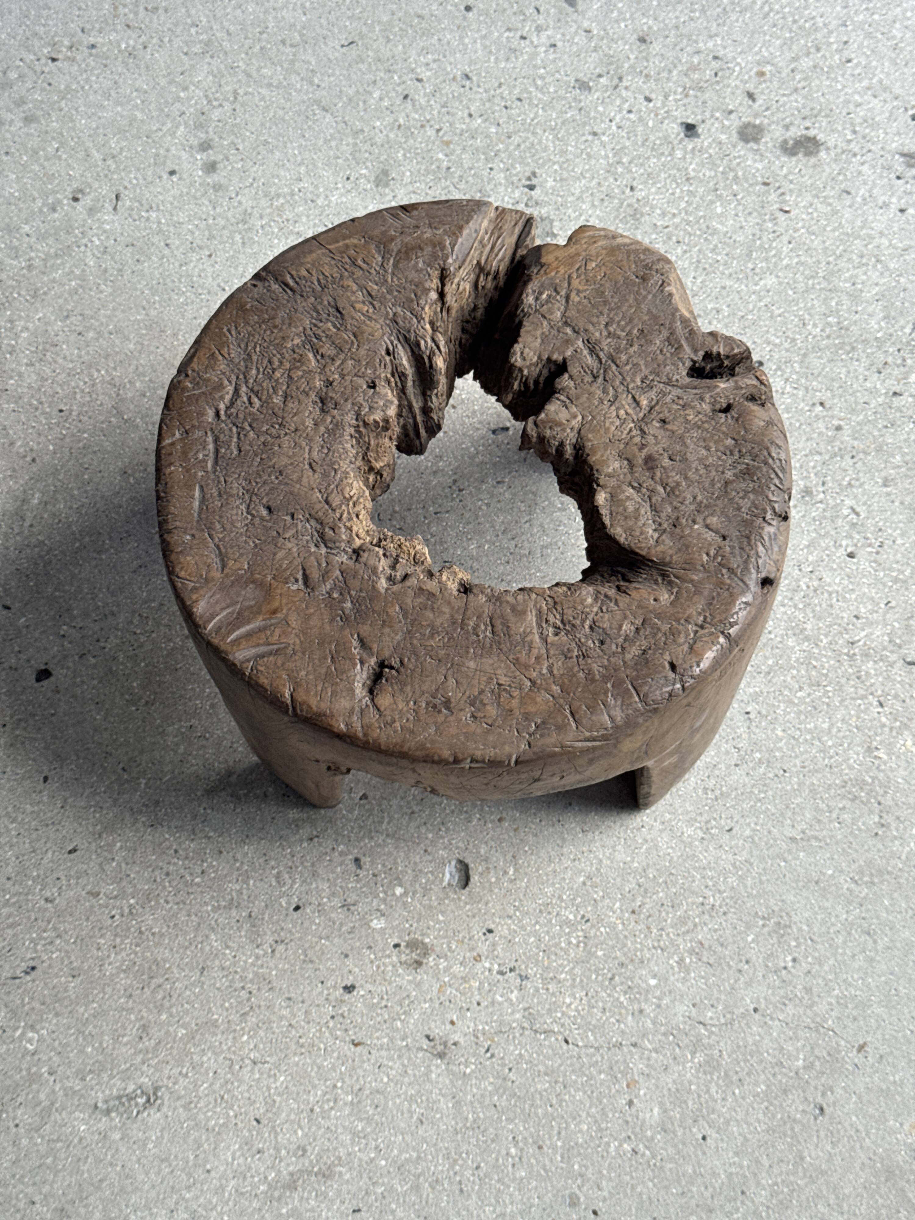 Small low circular four-legged stool in organic old teak with cut-out design H2