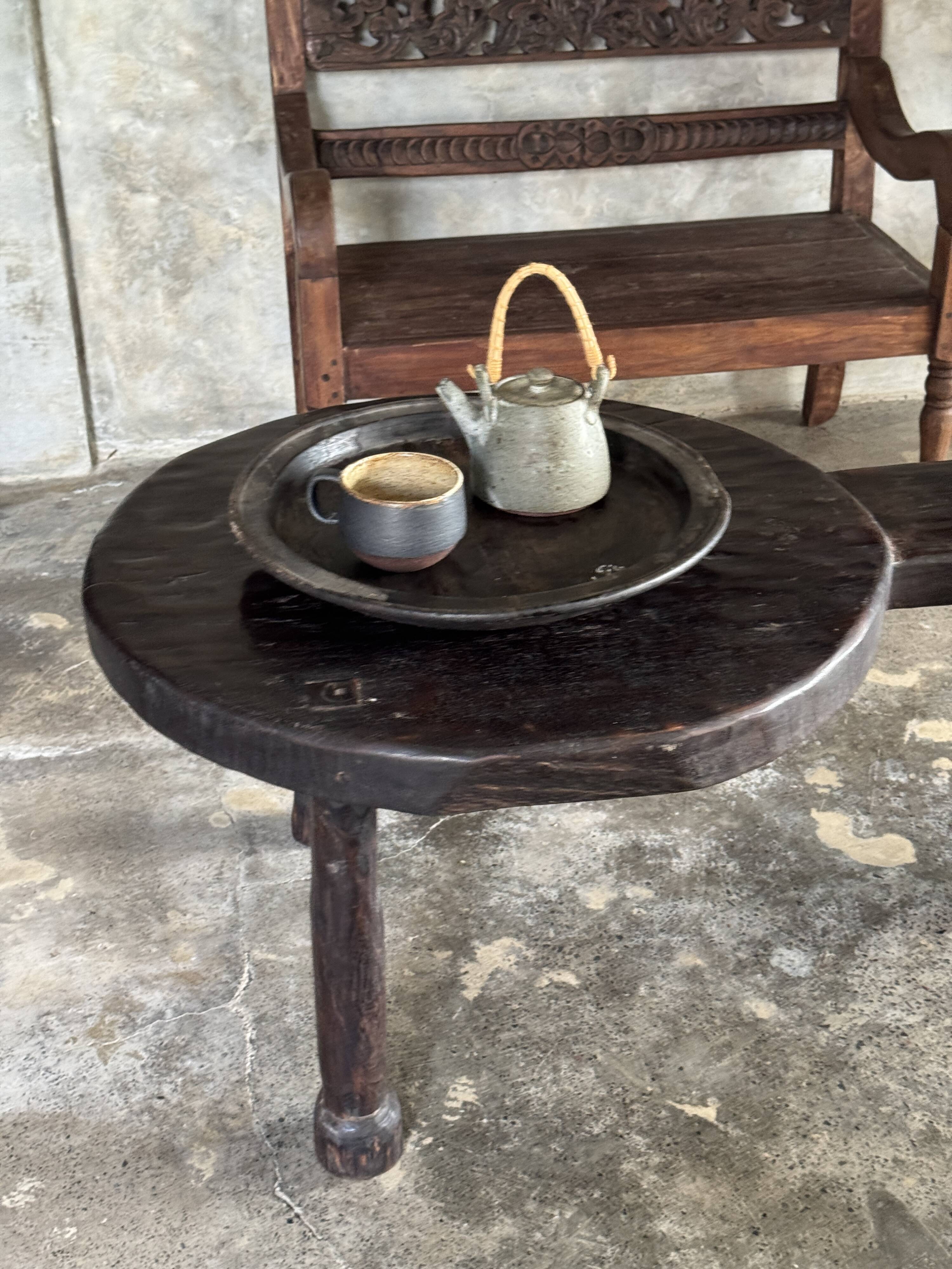Small antique Indonesian bench in carved teak with plant and floral motifs.