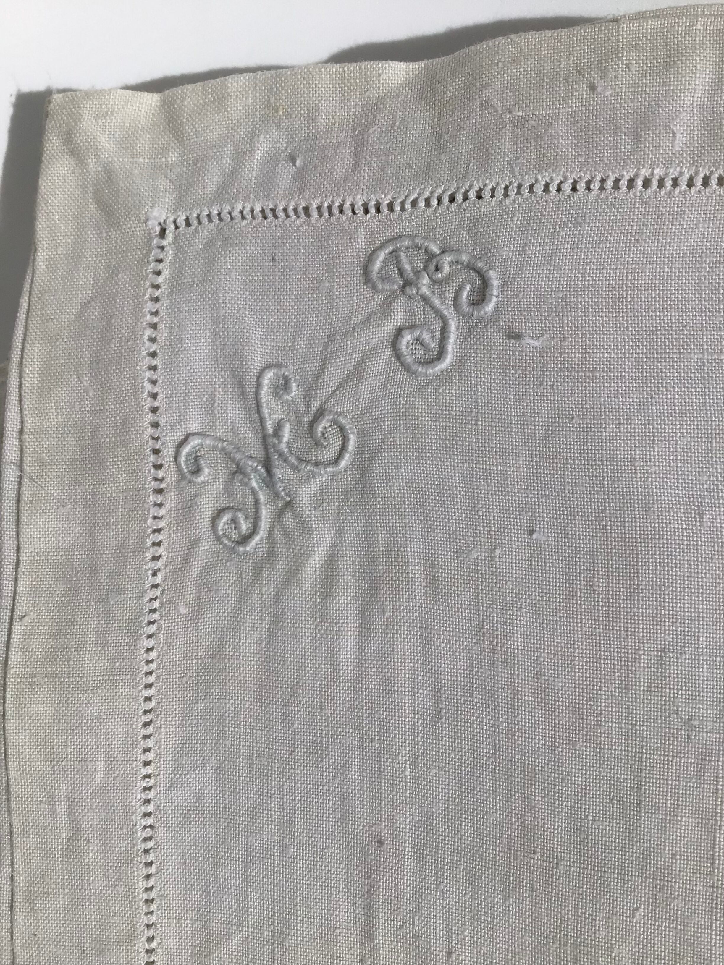 6 square linen napkins with hand-embroidered initials in the corner.