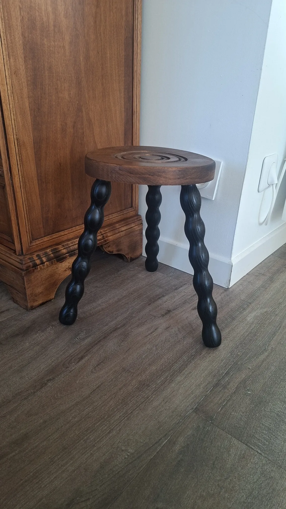Brown and black wooden tripod stool