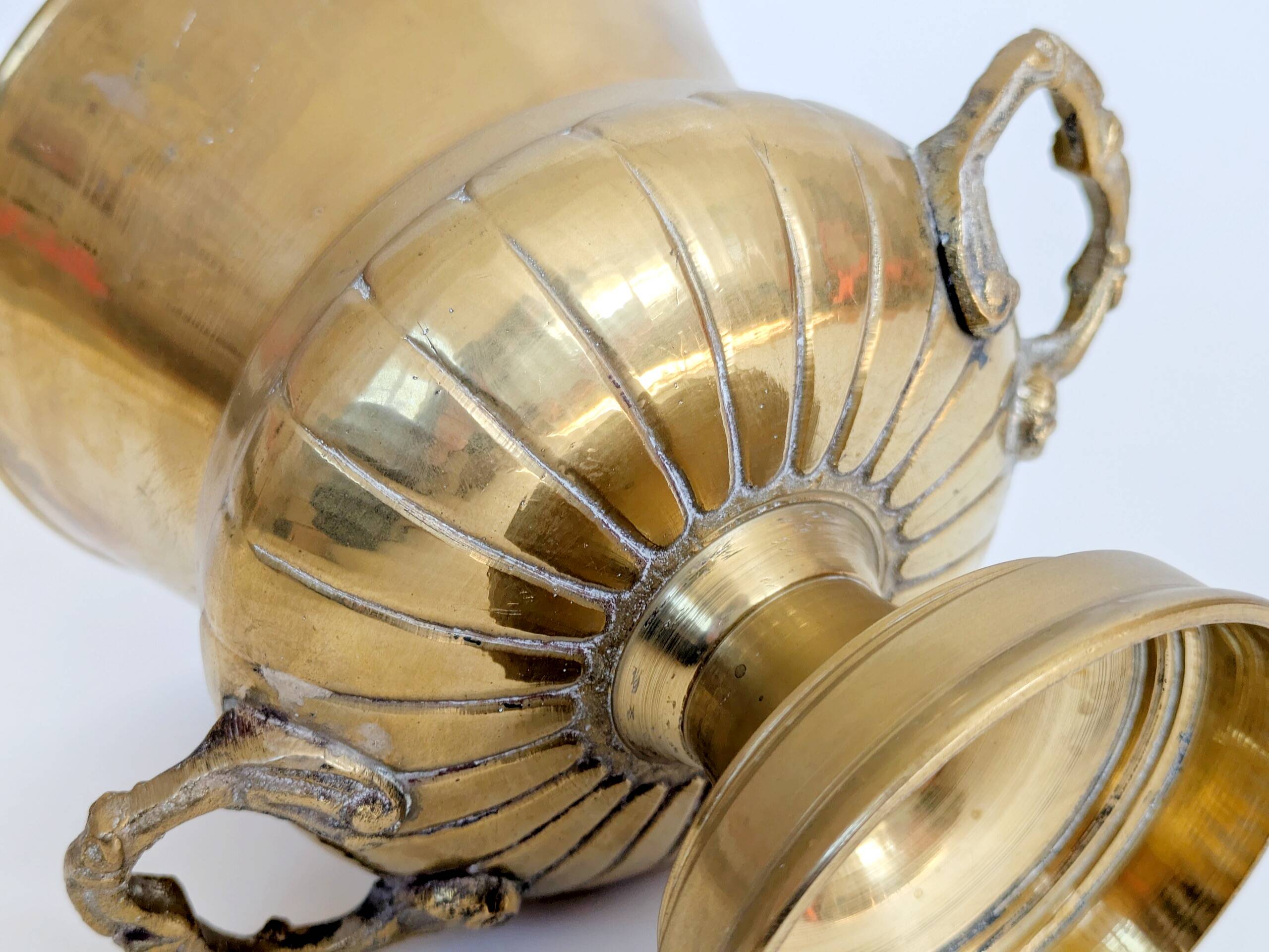 Vintage brass cache-pot on a stand with handles, classic decor.