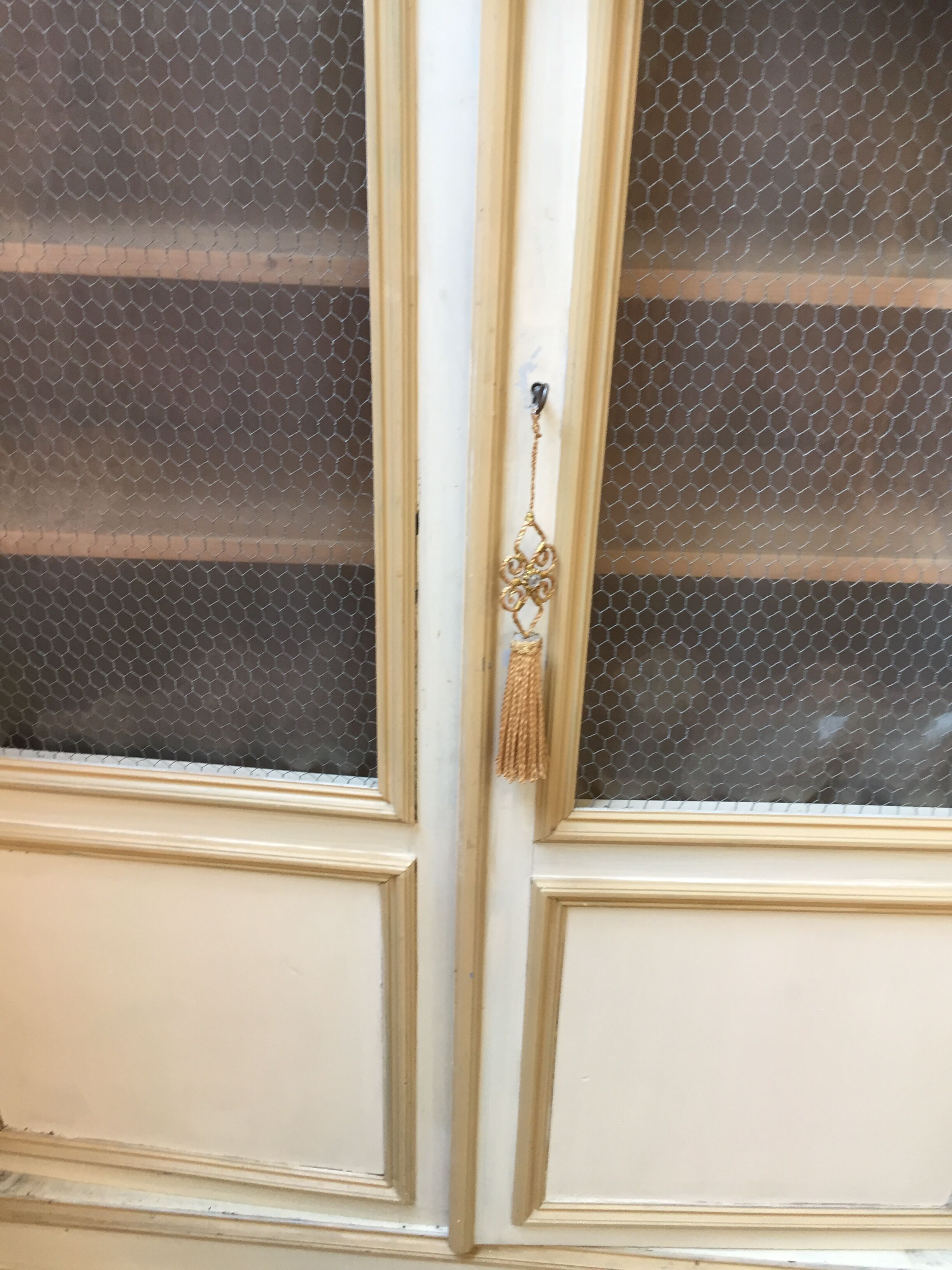 Bookcase 2 painted in ochre and cream mesh doors beginning 20 th