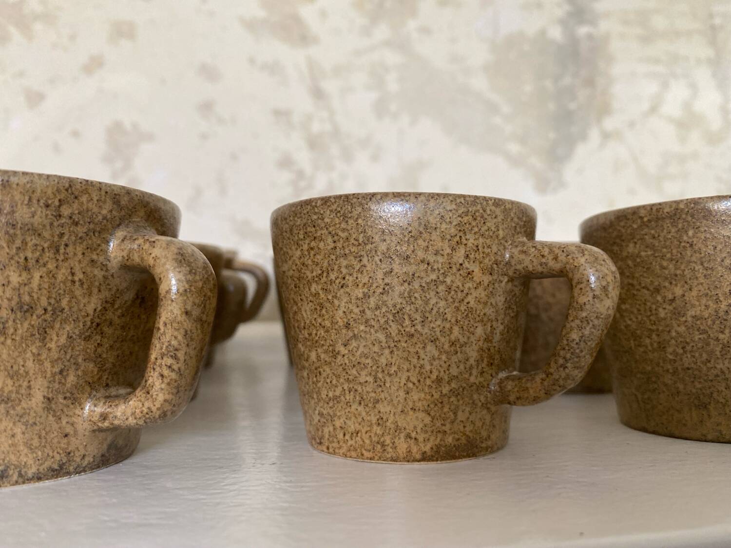 Set of stoneware coffee cups with saucers