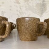 Set of stoneware coffee cups with saucers