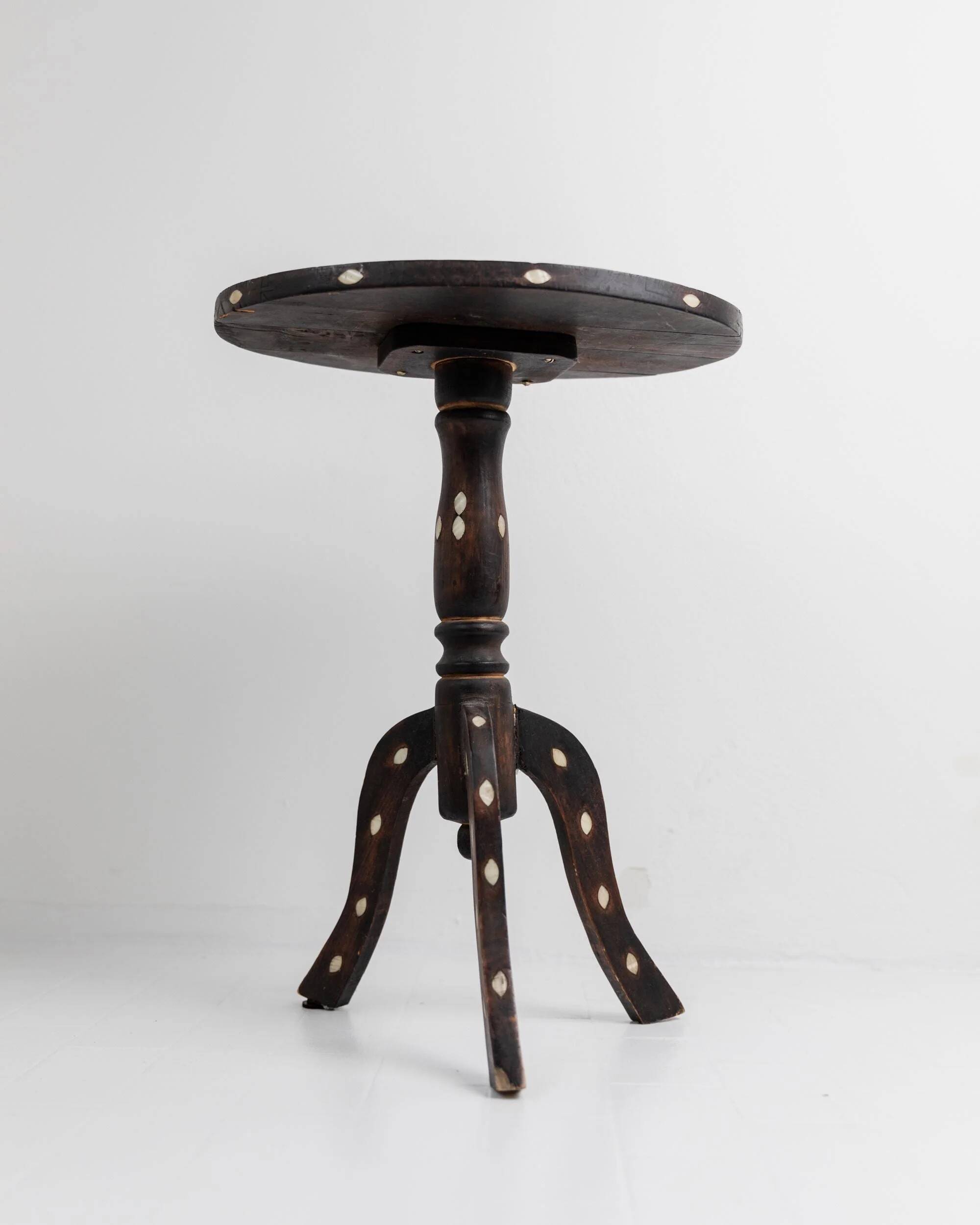 Vintage side table from the early 19th century, dark wood with mother-of-pearl inlays, oval shape with three legs, ethnic style.