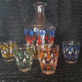 Vintage decanter and its 7 assorted glasses.