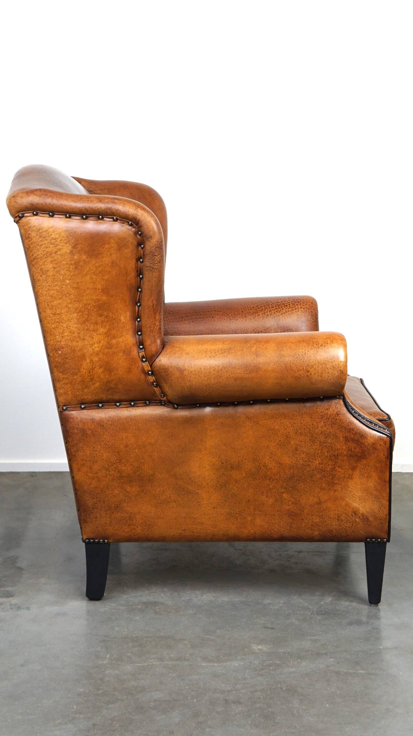 Sheepskin leather wingback armchair, with nails and black piping