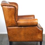 Sheepskin leather wingback armchair, with nails and black piping