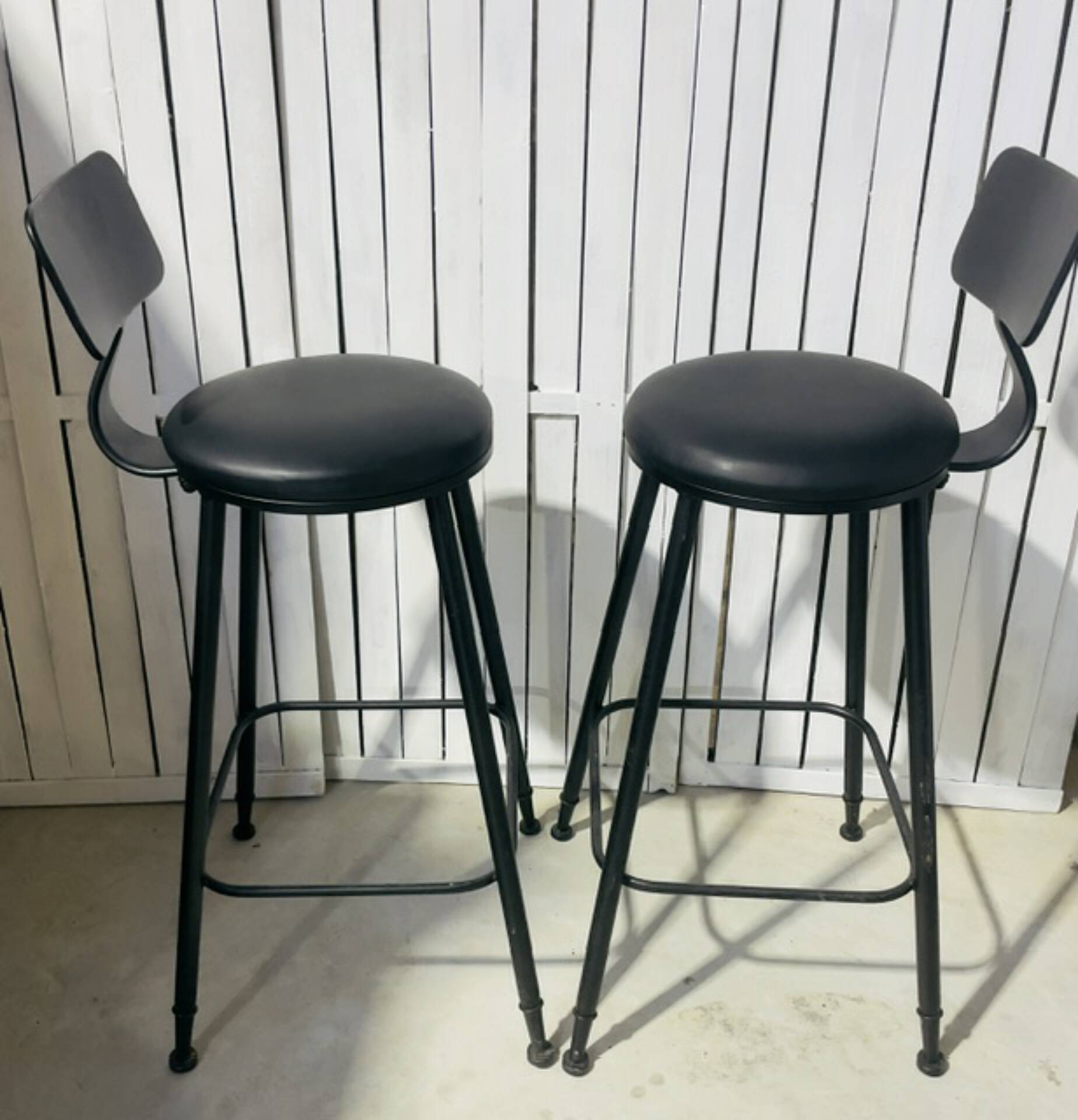Pair of black bar stools in industrial and contemporary style.