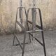 Large vintage industrial glass table with adjustable metal trestles.