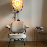 Vintage hairdresser's armchair with helmet transformed into a lamp