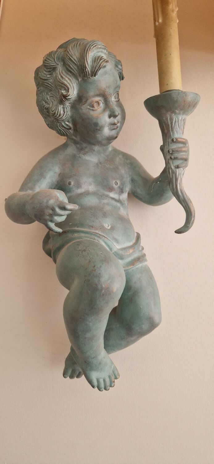 Pairs of wall lights, either two distinct cherubs.