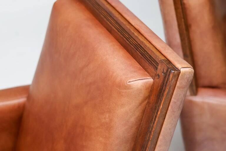 Pair of Art Deco armchairs in brown leather and teak, Netherlands, 1970s.