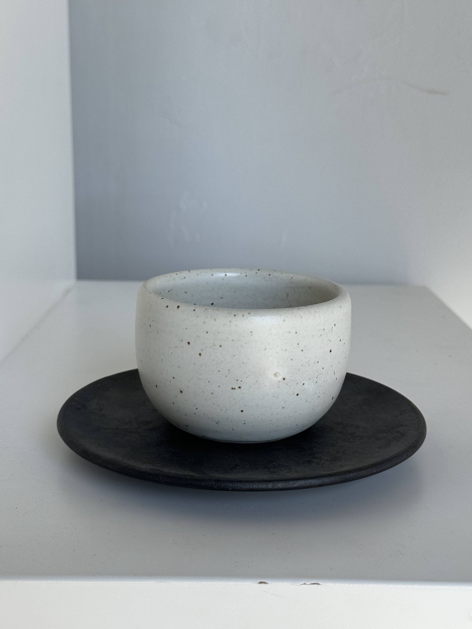 Tasse blanche en céramique indonésienne et soucoupe grise