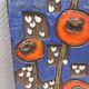 Ceramic relief in attractive blue with a motif of white/red flowers.