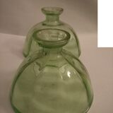 Two bottles in glass, (certainly), surroundings of the 1930s