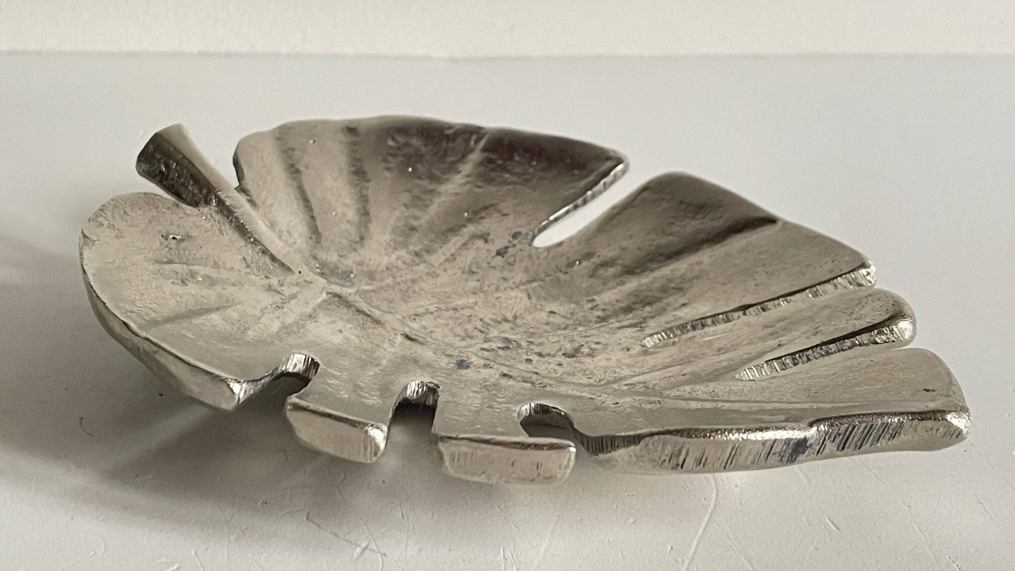 Leaf-shaped metal pocket emptier
