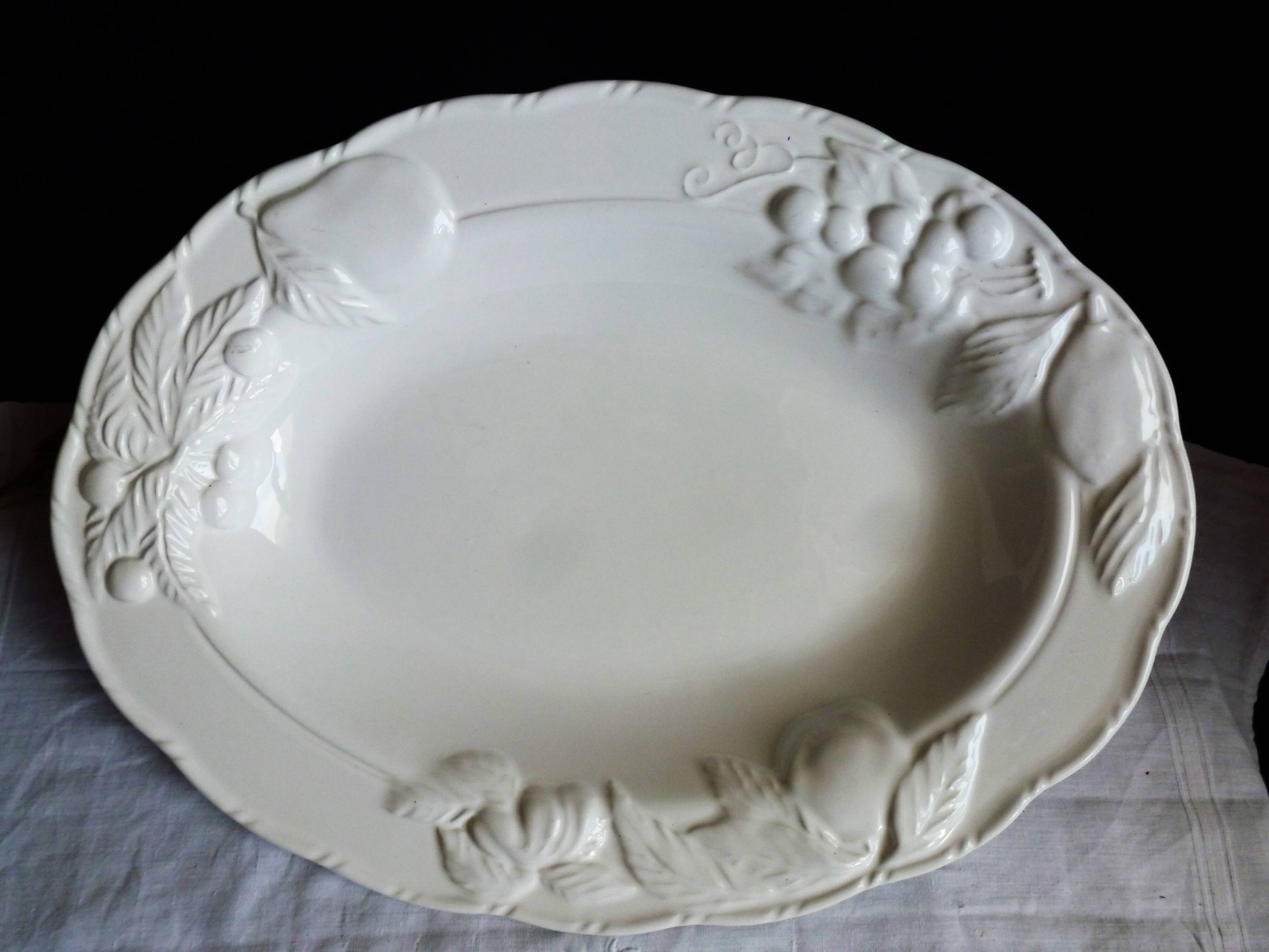 Oval white vegetable dish, an antique tableware piece in barbotine earthenware.