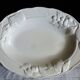 Oval white vegetable dish, an antique tableware piece in barbotine earthenware.