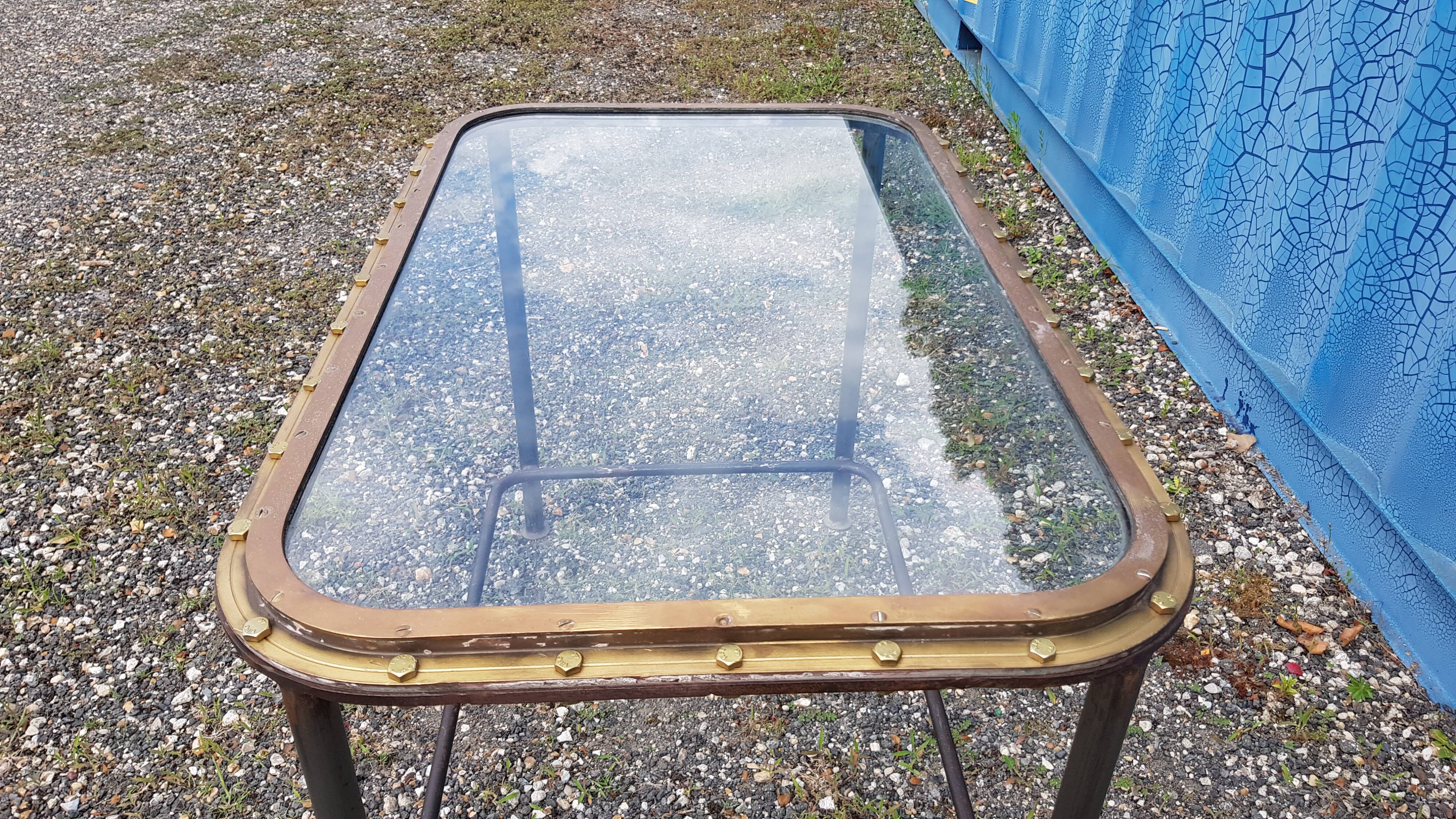 Table with an old ship porthole in brass and a metal base / 110 x 70 x 76 cm