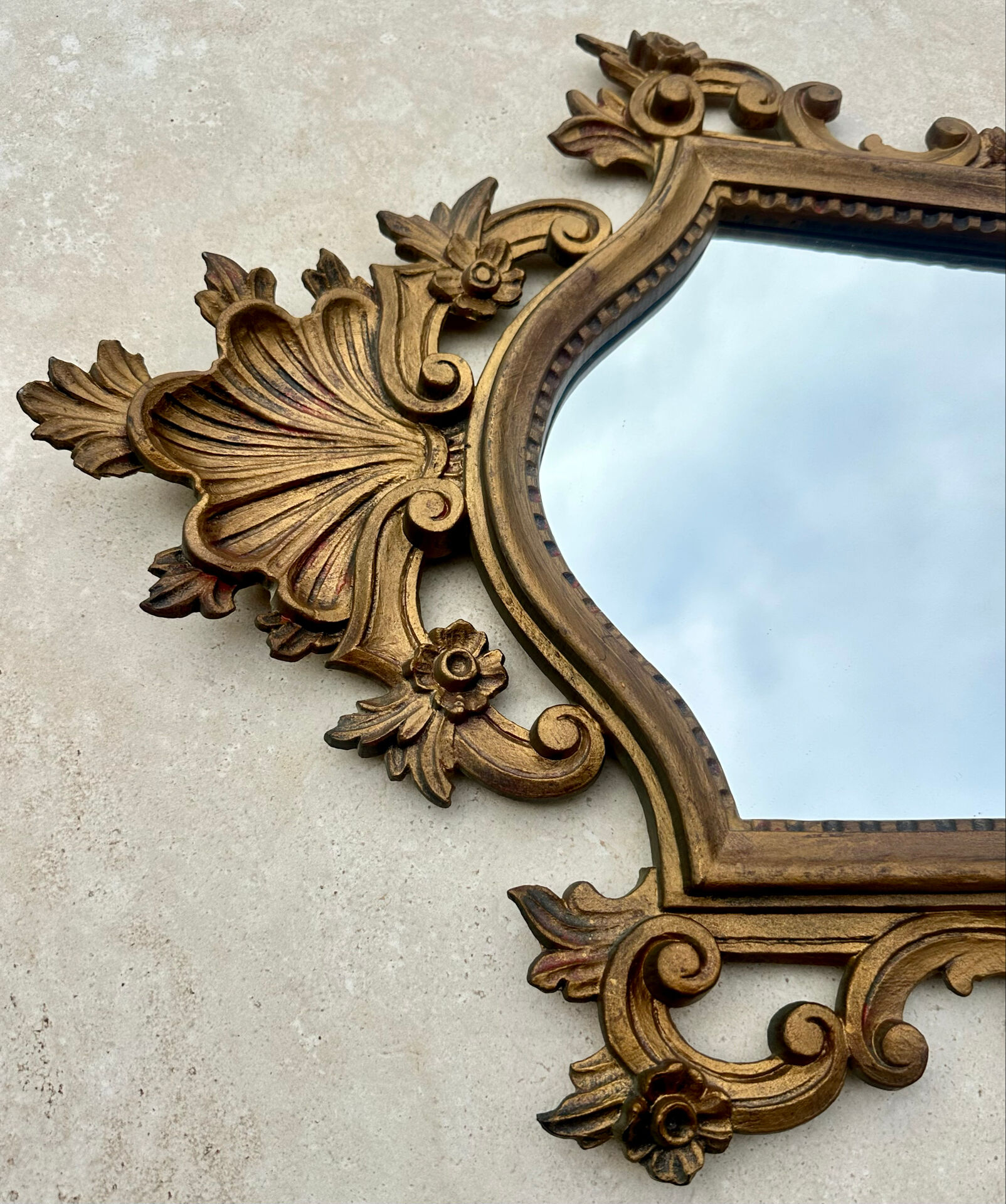 Carved and gilded wooden wall mirror.