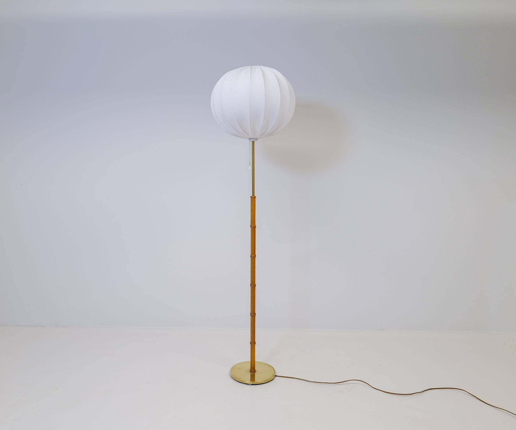Mid-century floor lamp in brass and oak by Falkenbergs Belysning, Sweden, 1960s.