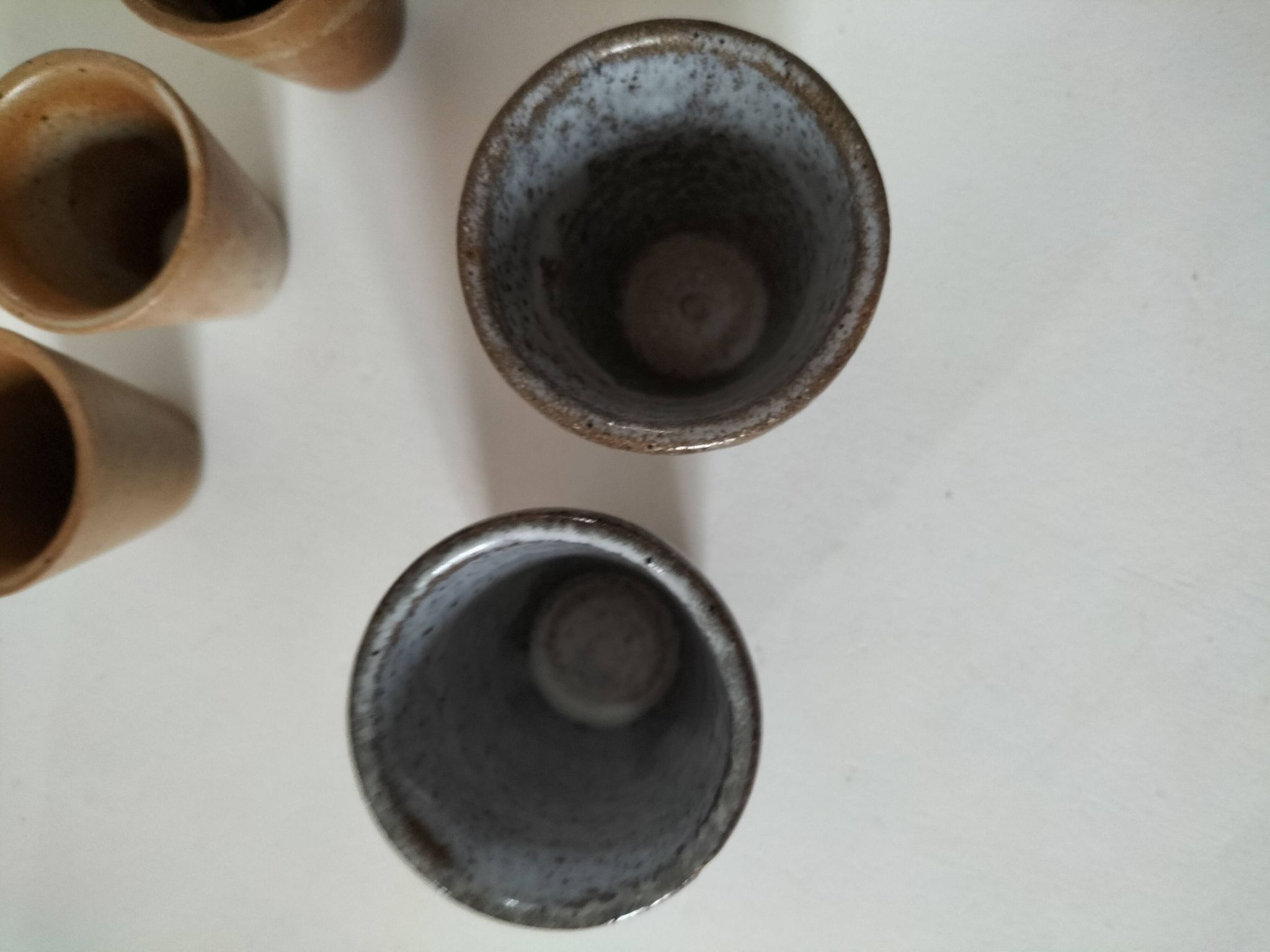 Set of 8 stoneware cups and a mug, shades of beige.