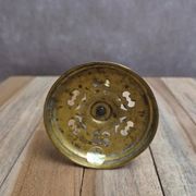 Antique brass candlestick with patina, openwork vintage foliage decoration.