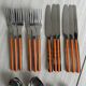 24 vintage stainless steel and orange plastic cutlery sets