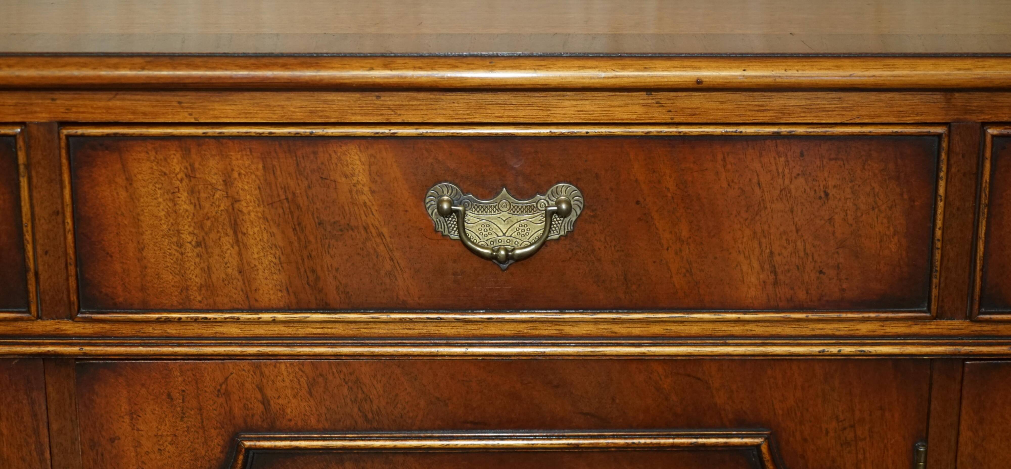 Vintage mahogany buffet with three drawers and shelves.