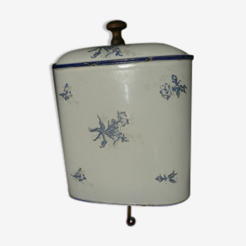 Old wall fountain in enamelled sheet metal decorated with blue flowers on a white background
