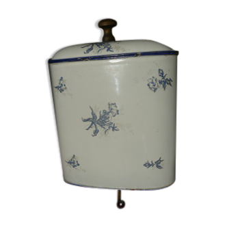 Old wall fountain in enamelled sheet metal decorated with blue flowers on a white background