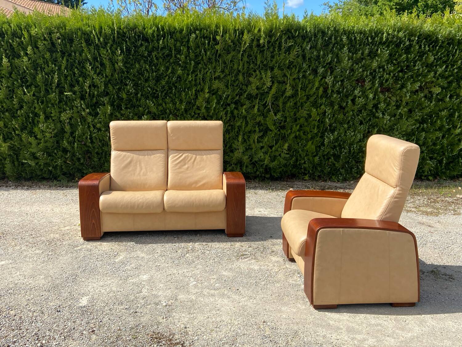 Set of vintage armchair and 2-seater sofa in beige leather and reclining wooden armrests, stressless style