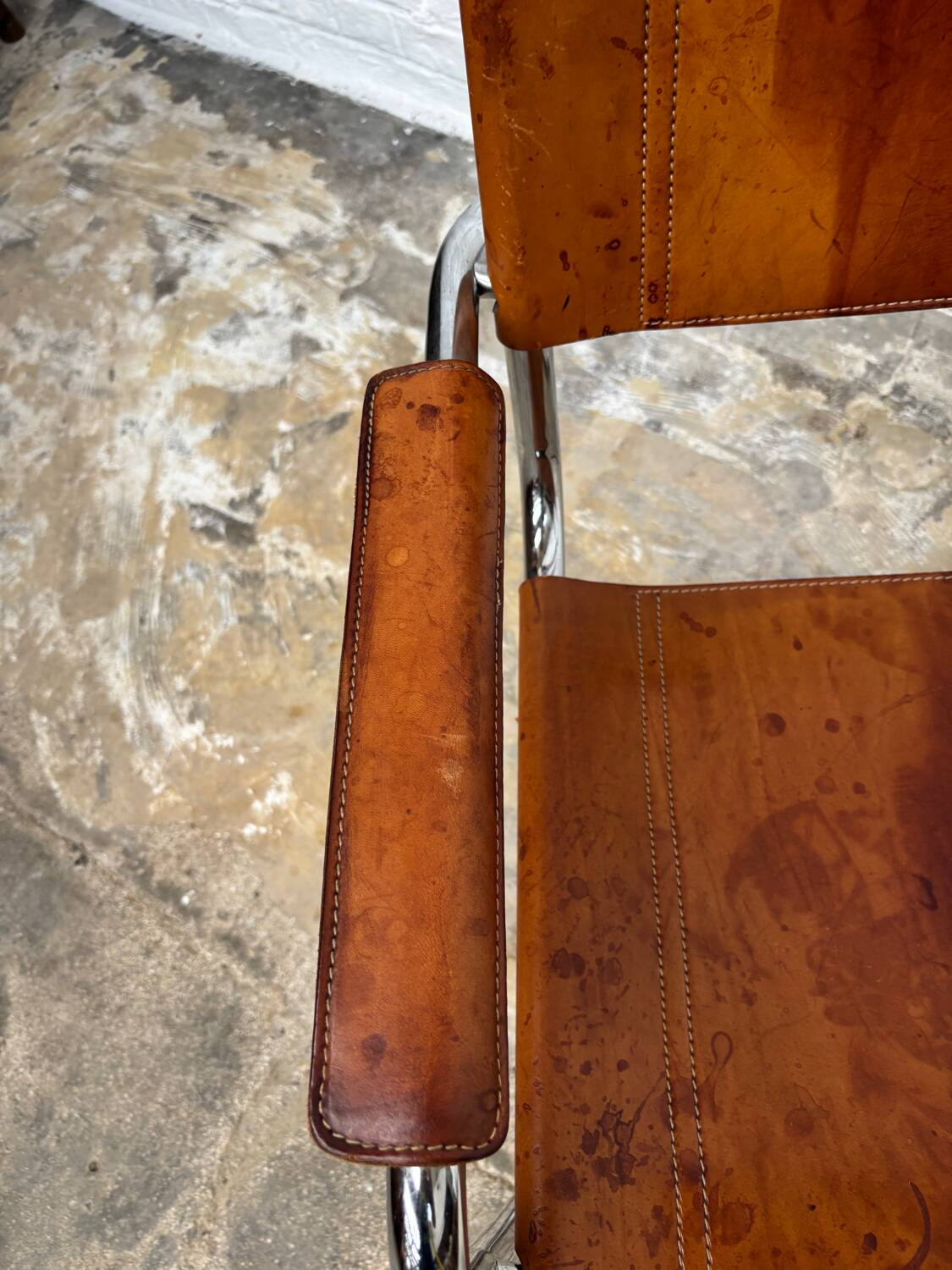 Vintage aluminum tube and tan leather armchair