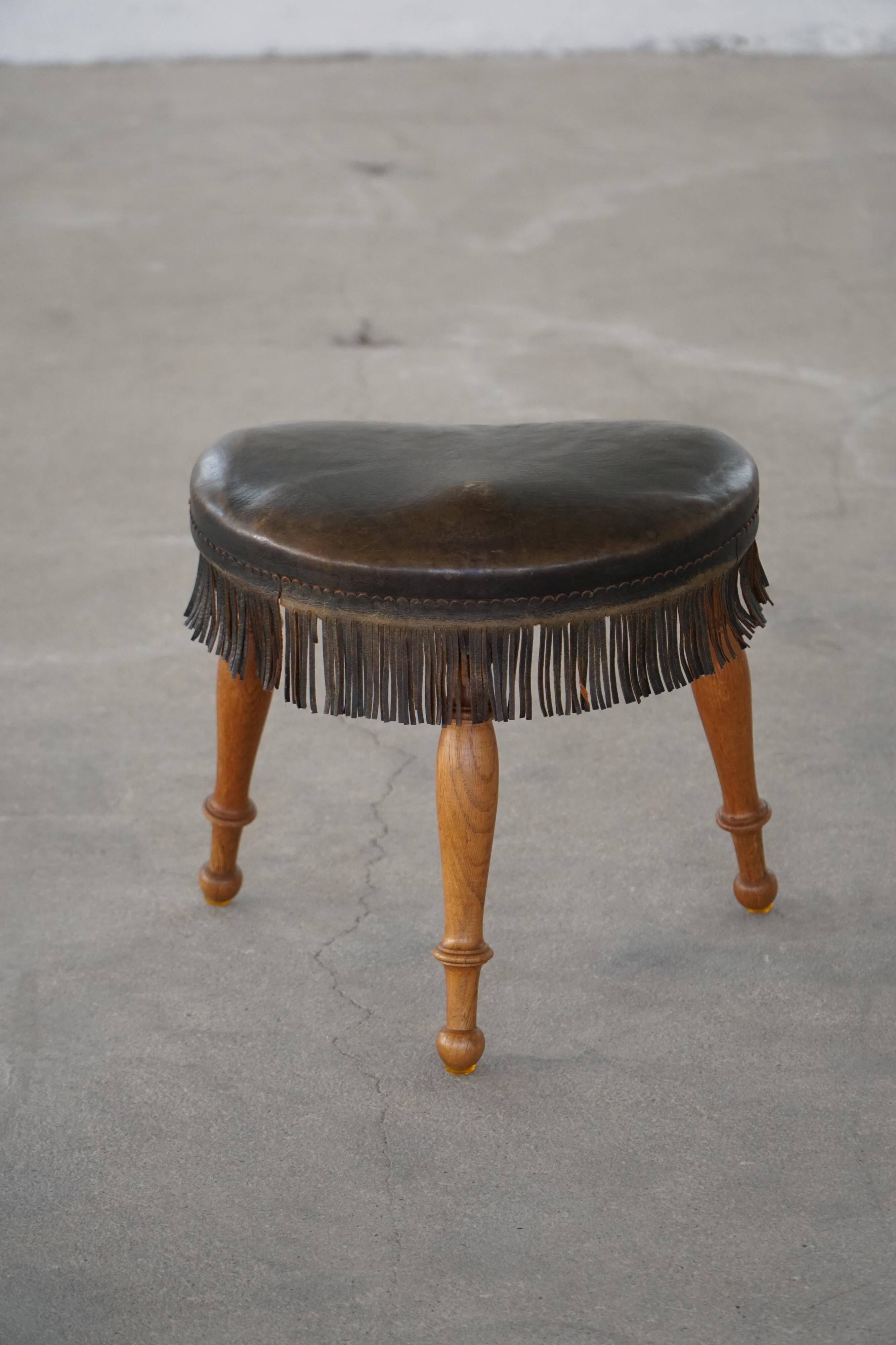 Danish oak tripod stool from the early 20th century with leather fringe, 1930s.