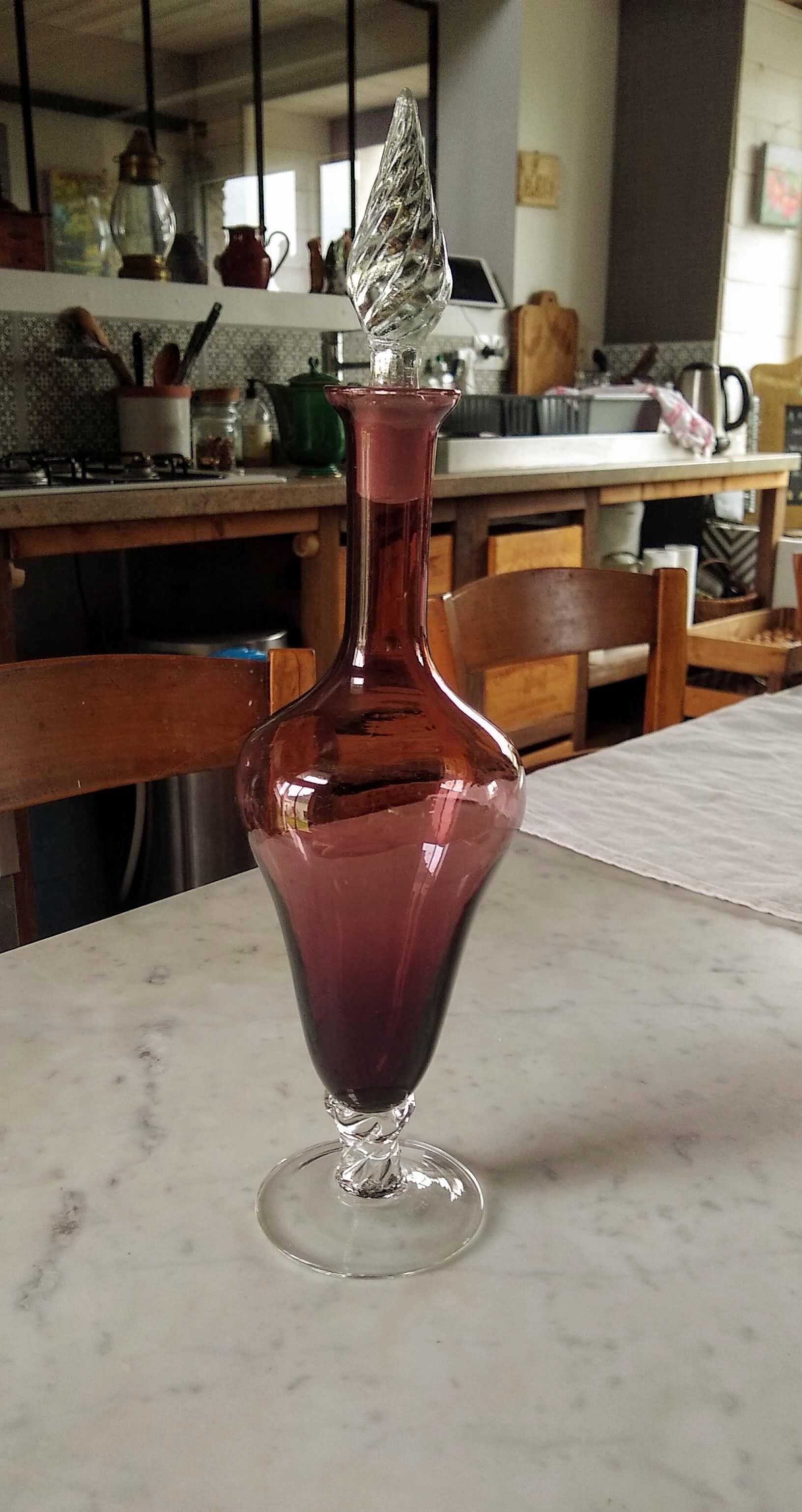 Purple-colored liquor-blown glass decanter with carved foot