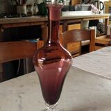 Purple-colored liquor-blown glass decanter with carved foot
